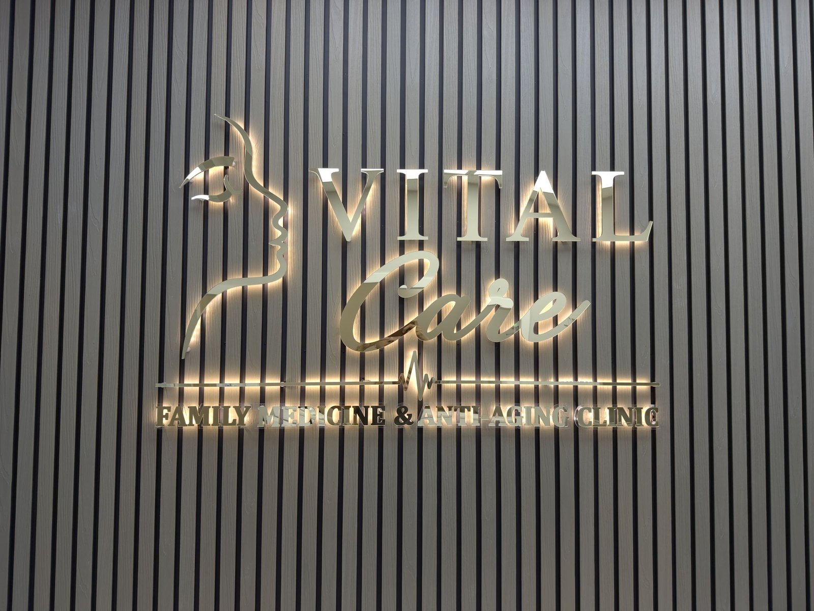 Backlit gold metal letters on a slat wall for a clinic