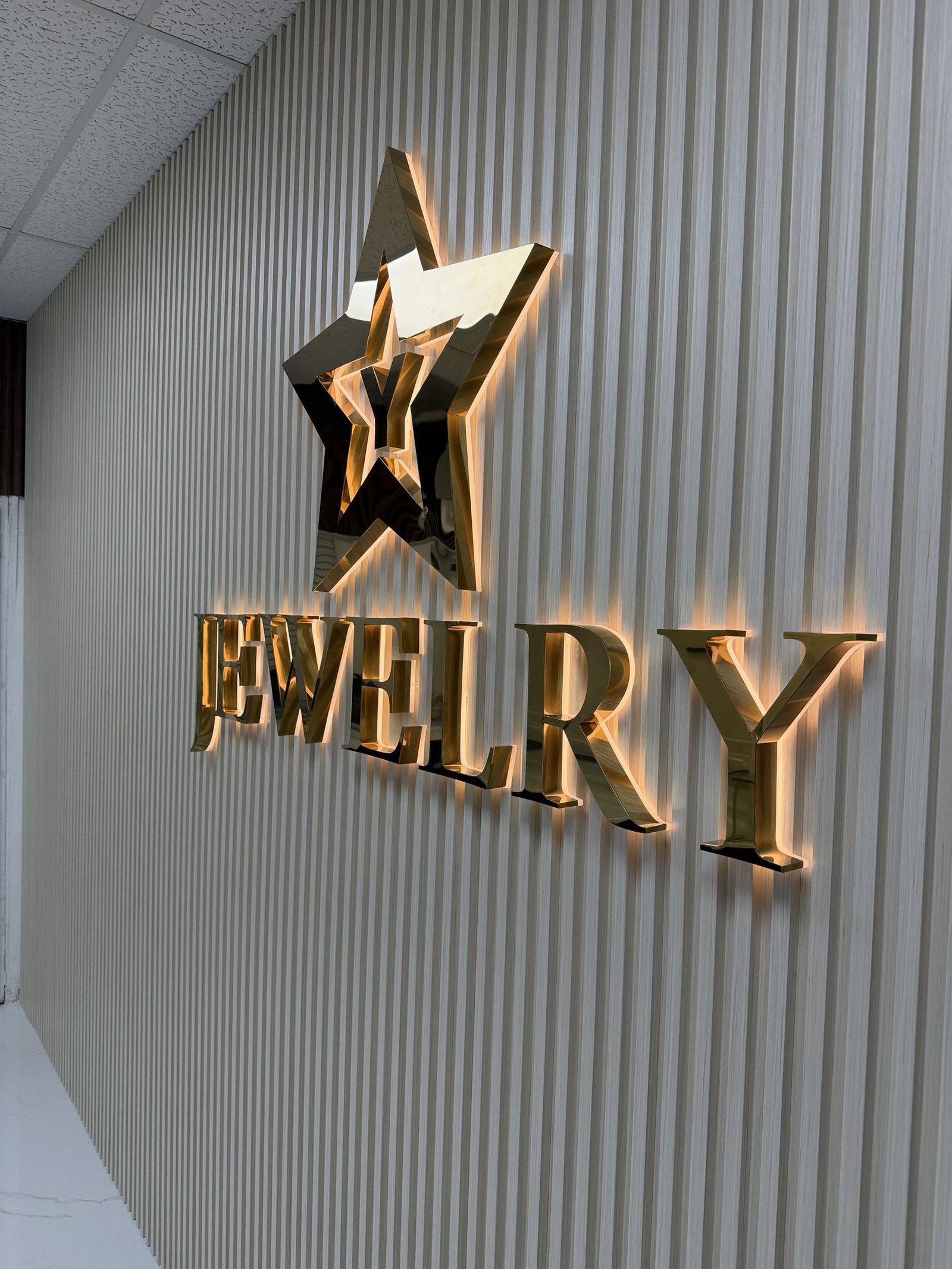 Polished gold metal letters and star logo with halo lighting for a jewelry store